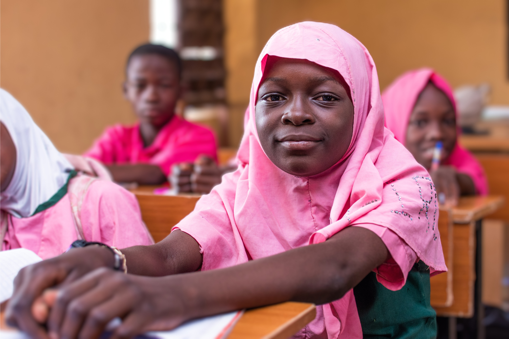 Tawakalit Abdulazeez sitting with her peers in the classroom.