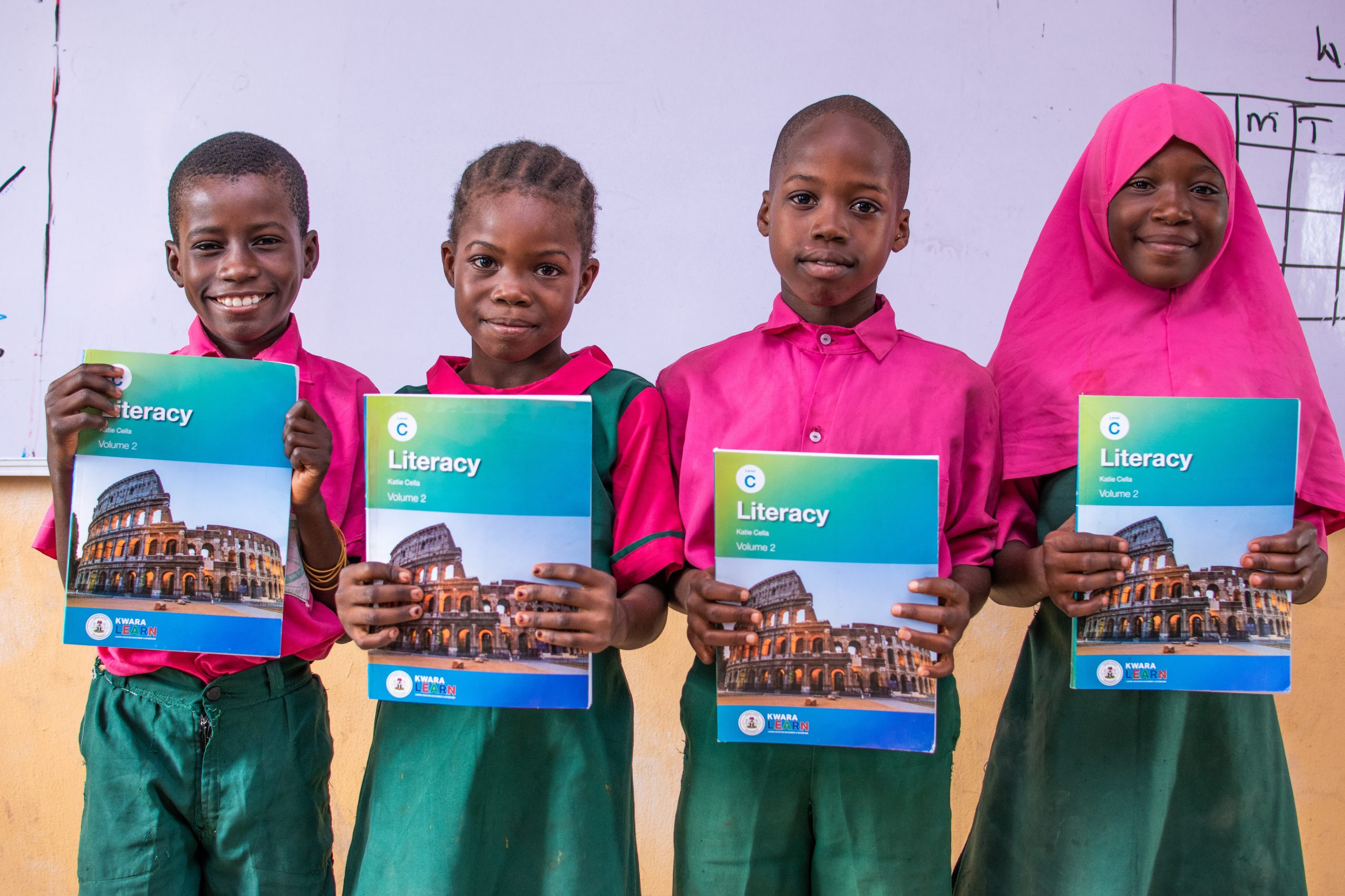 KwaraLEARN pupils happily holding their literacy textbook.